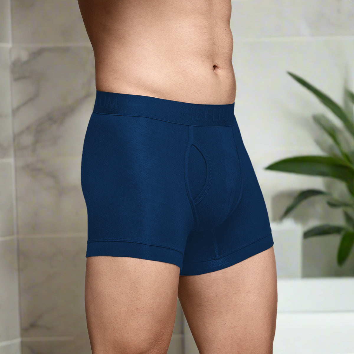 Front view of Heelium navy keyhole bamboo trunks worn by a model